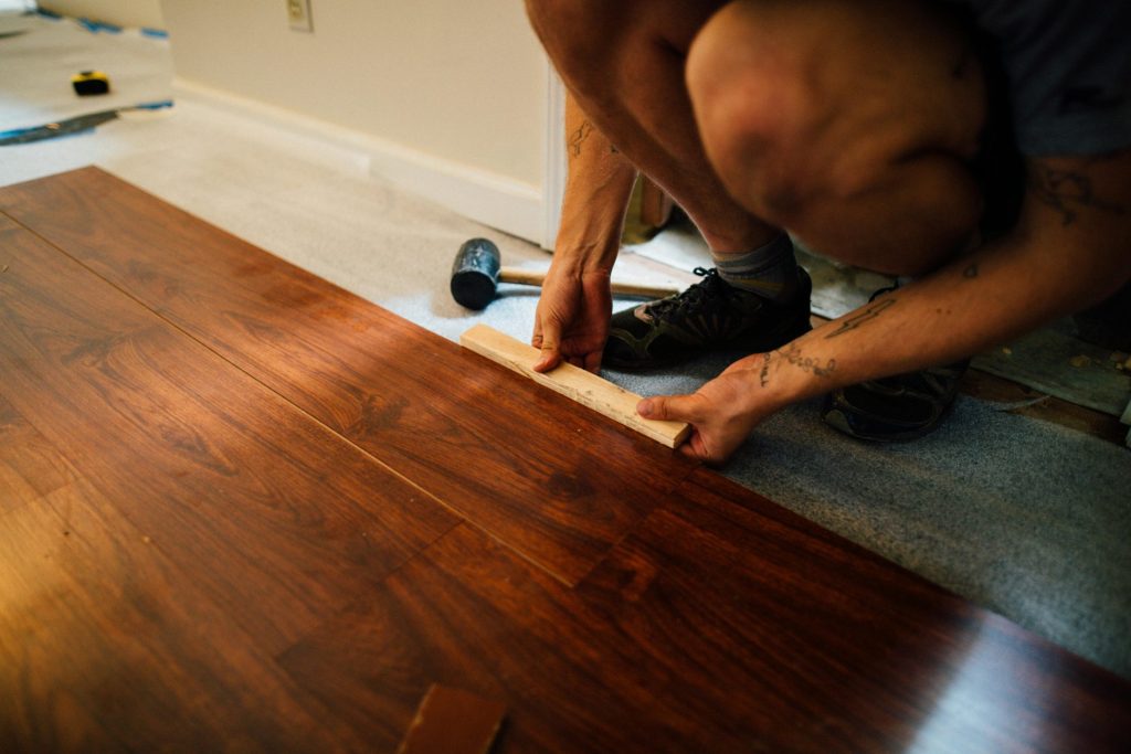 Crop man installing laminate flooring